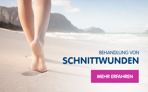 Füße, die am Meer durch den Sand laufen
